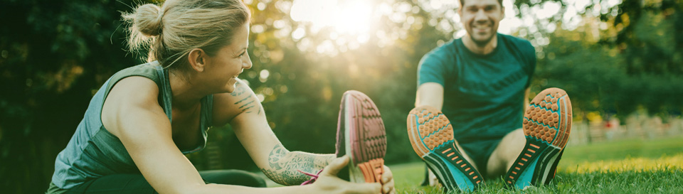 Picture of a couple streching together in a park